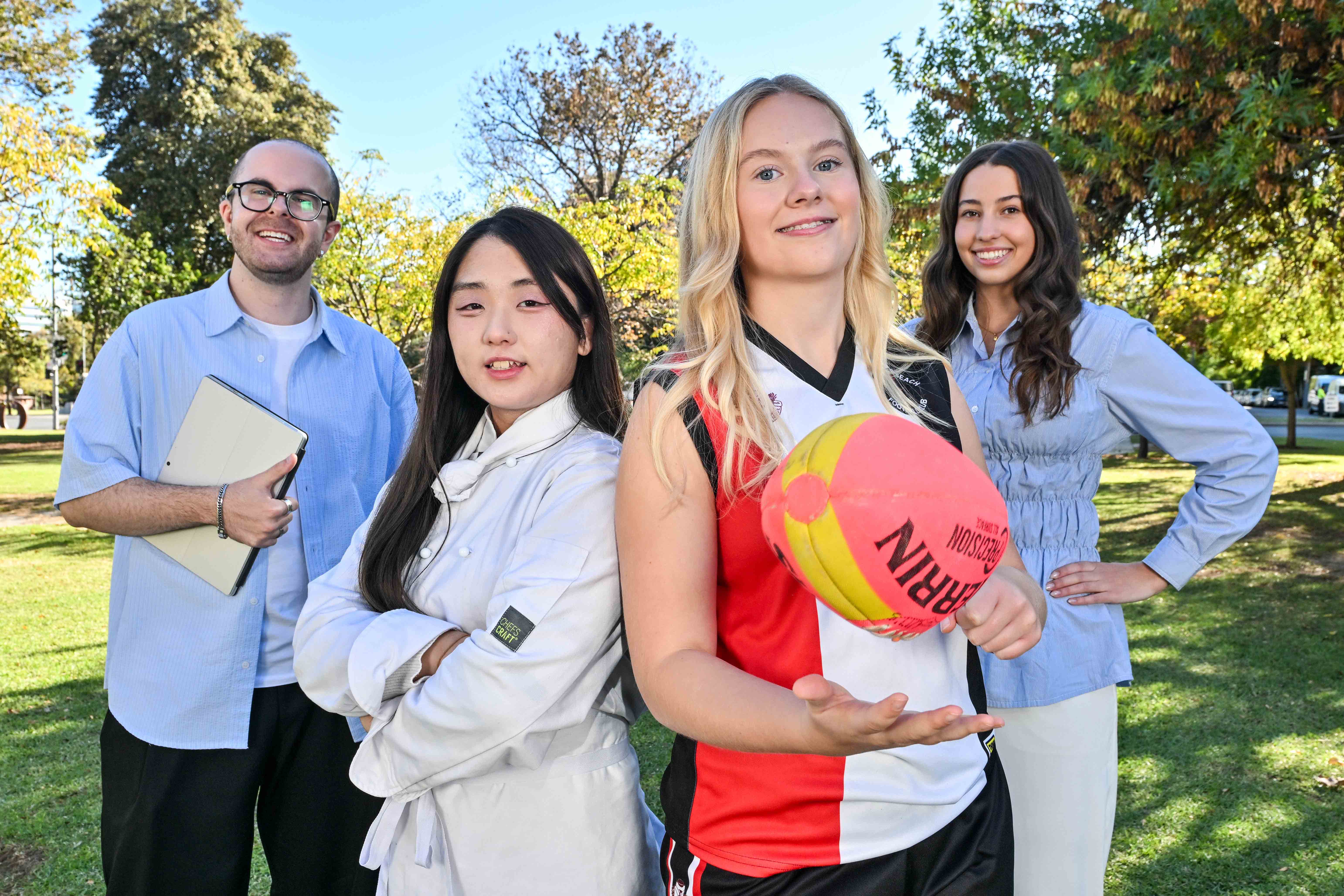 Four students pictured together from Australia, Korea and Norwegia. One student is holding a football.